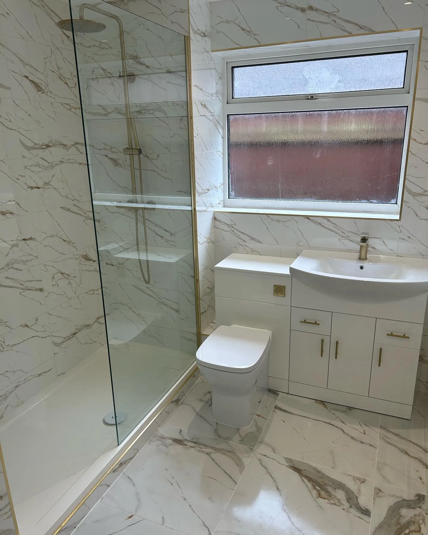 Luxury marble bathroom with gold shower enclosure installed by H2O Heating Solutions