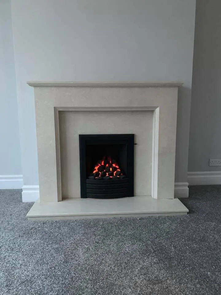 Limestone fireplace with glowing gas fire installed by H2O Heating Solutions